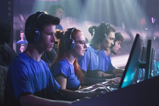 esports gamers sitting at row of desktop computers